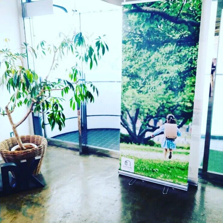 conosakiブランドの緑の樹木の背景のロール看板の写真