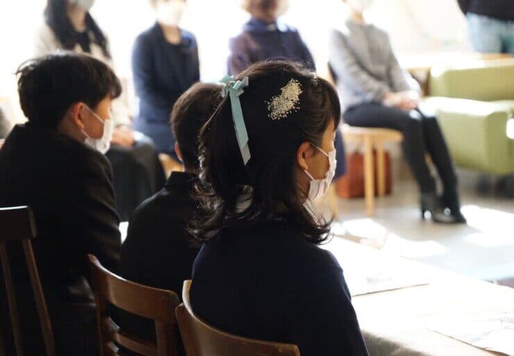 小学生の卒業生が椅子に座り、式に望む卒業式の光景